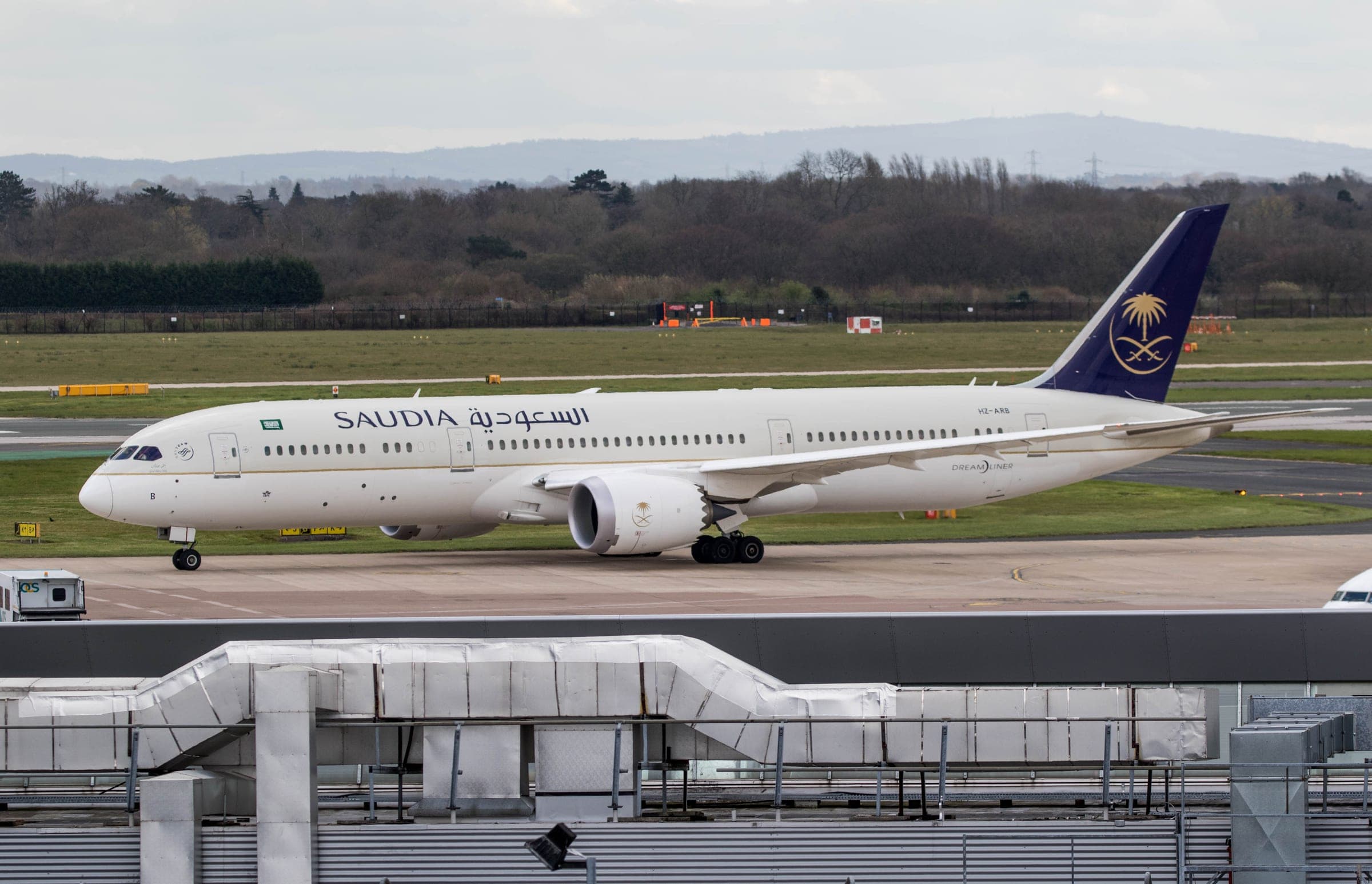 A Saudia Boeing 787-9 Dreamliner taxiing in the airline's white, green and gold livery.