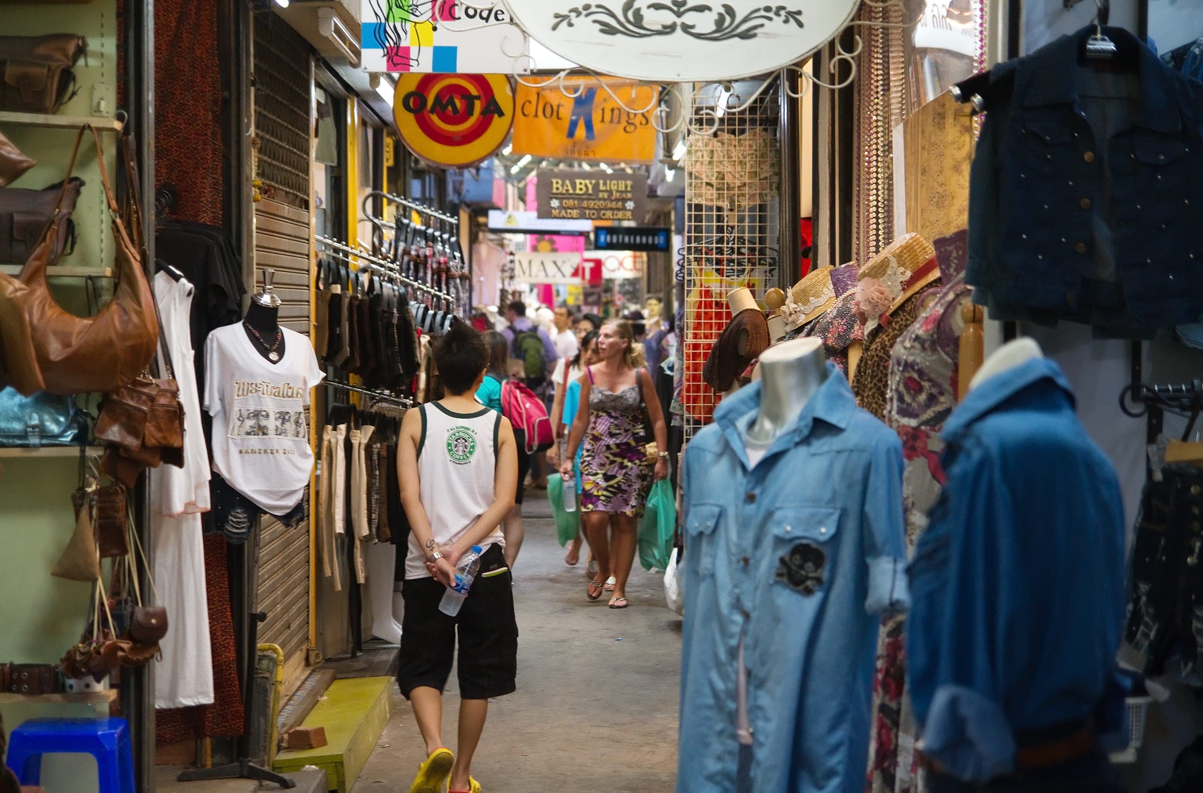 A narrow lane of clothes stalls at Chatuchak Weekend Market, Bangkok.