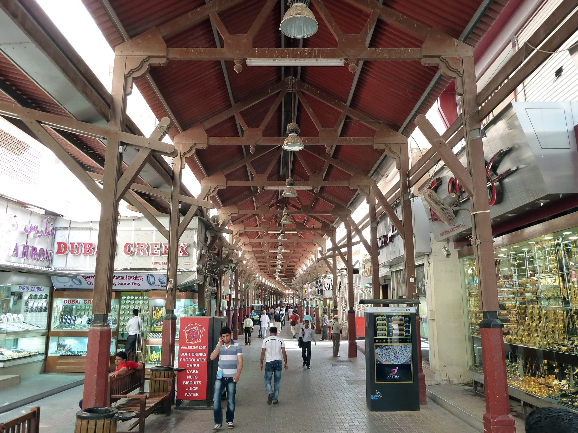 The covered walkway of the Dubai Gold Souk, shopfronts lit on both sides.