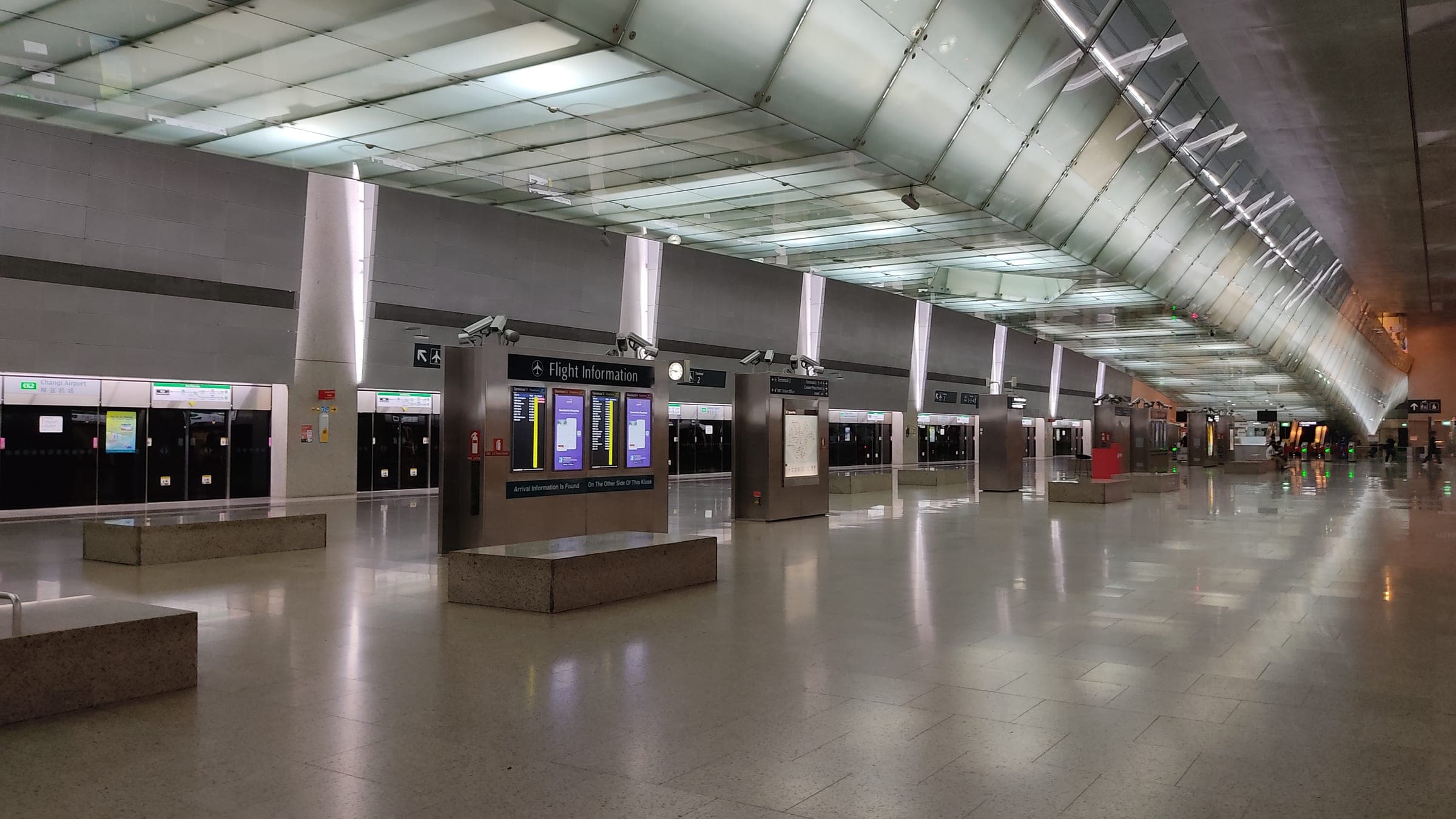 The platforms of Changi Airport MRT station in Singapore, empty and brightly lit.